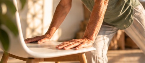 Exercice de yoga sur chaise, mains posées sur l'assise