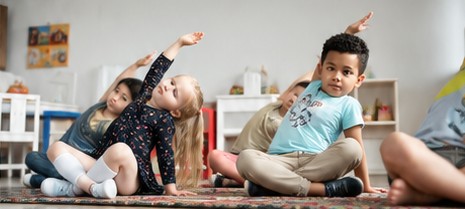 Enfants en posture d'étirement pendant un cours de yoga