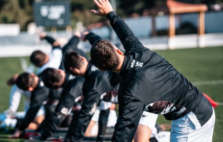 Footballeurs en étirement latéral sur le terrain
