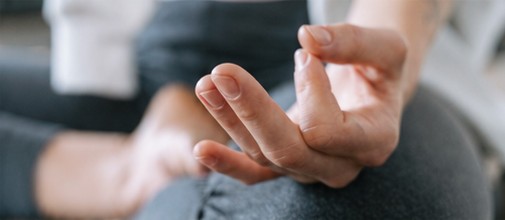 Mains en position de méditation pendant un cours de Hatha