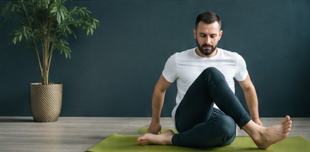 Homme en posture de torsion assise sur un tapis de yoga